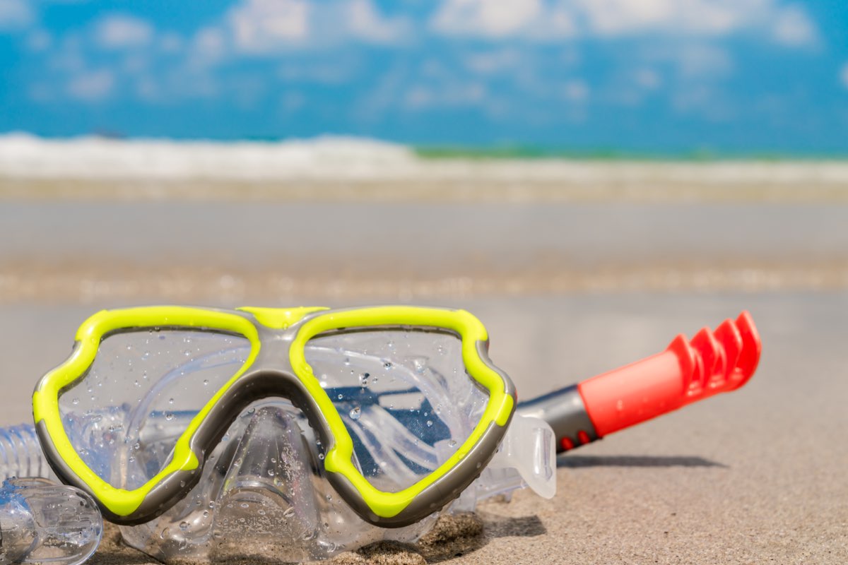 Snorkel mask and fins on the beach