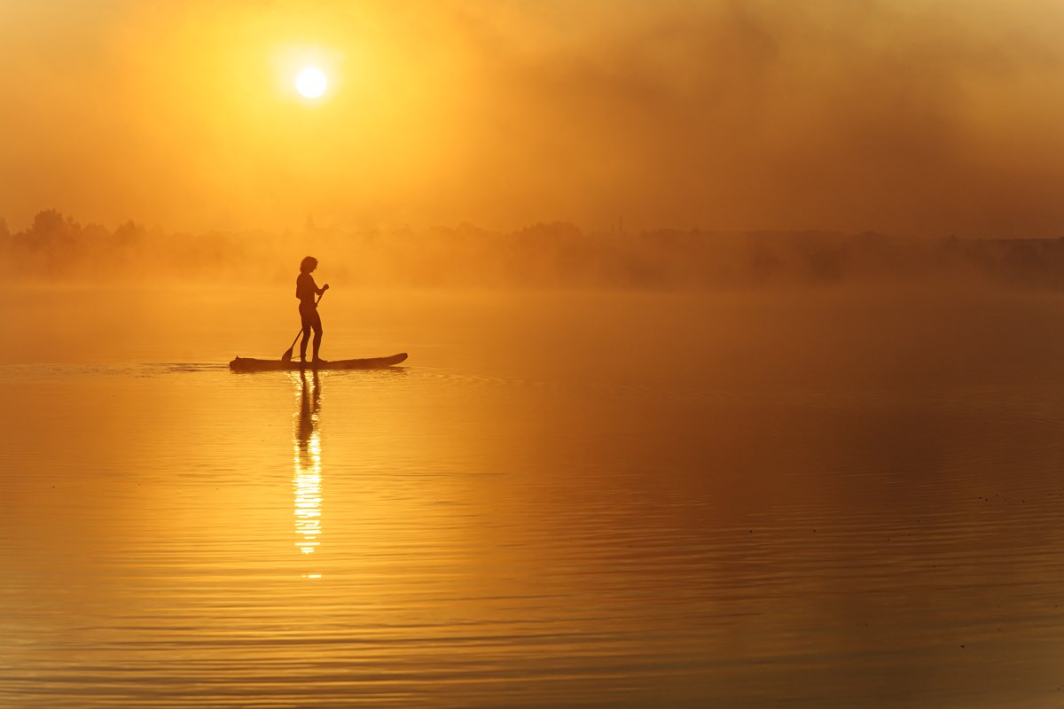 Paddleboarder at sunrise